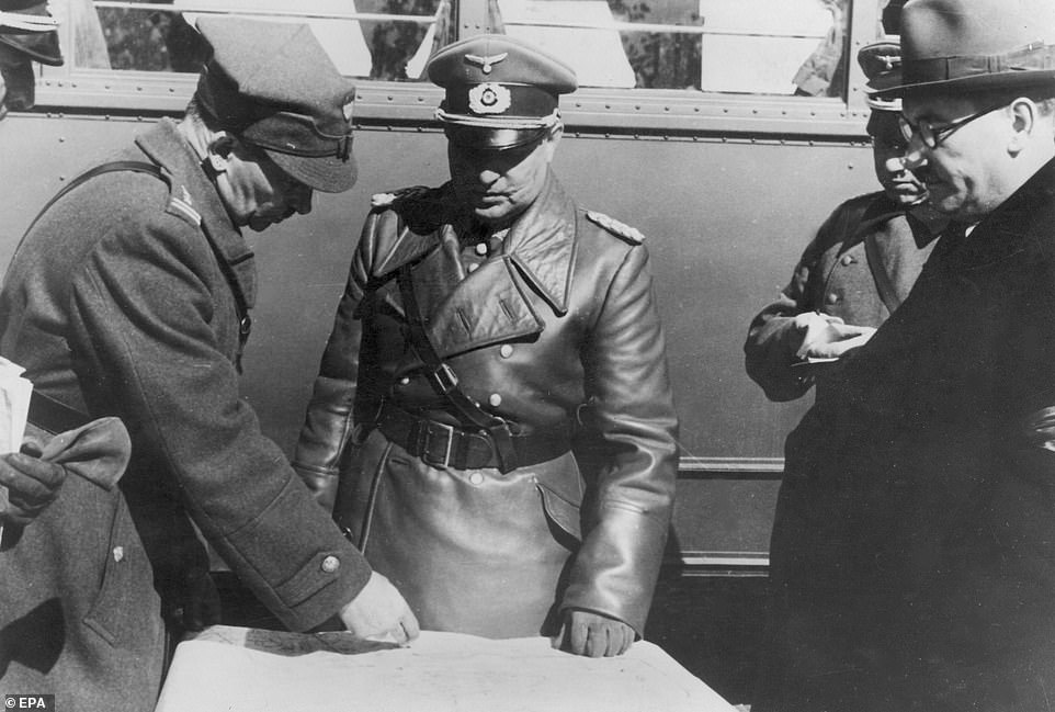 Вверху: польский полковник (слева) стоит над картой рядом с немецким генералом Гюнтером фон Клюге во время переговоров после капитуляции Варшавы гитлеровским войскам. Во время вторжения фон Клюге командовал немецкой 4-й армией вермахта